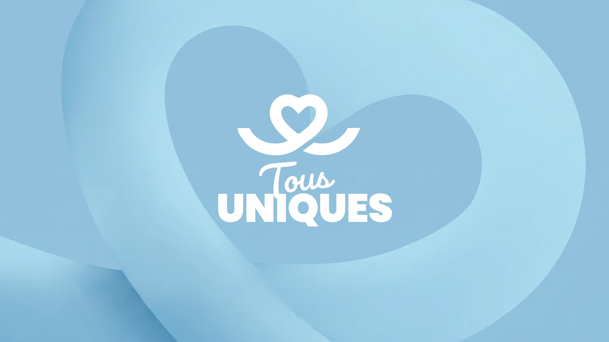 Le logo Tous Uniques en blanc au centre d'un grand cœur bleu en relief